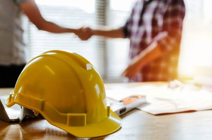 yellow-helmet-and-workers-shaking-hands