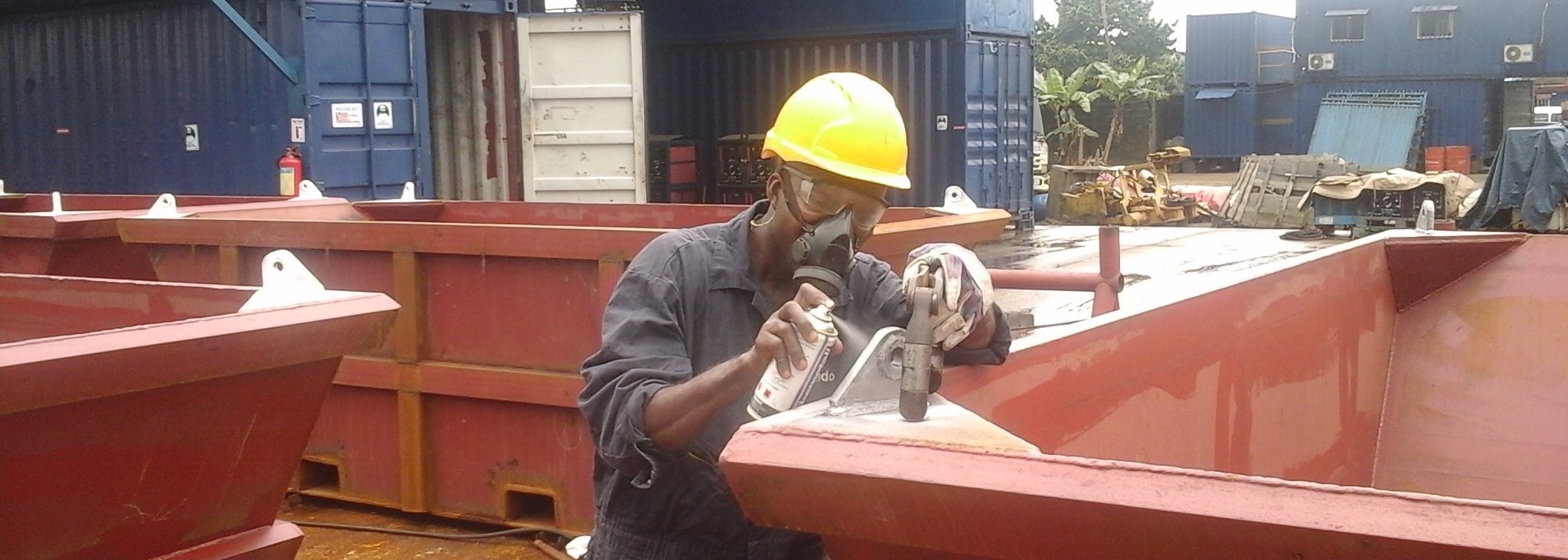 welder-spray-painting-padeye-on-waste-skip
