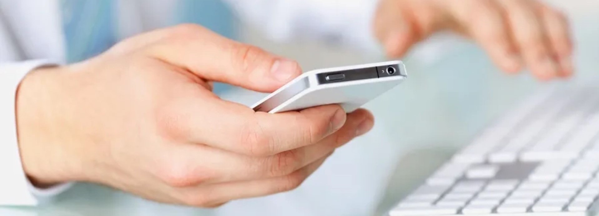 user-holding-phone-and-typing-on-keyboard